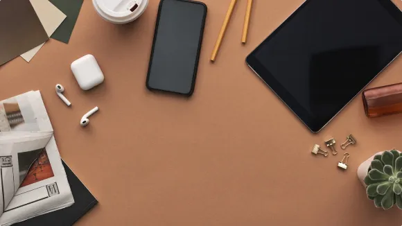 Headphones, phone, ipad, pencil, coffee on a desk